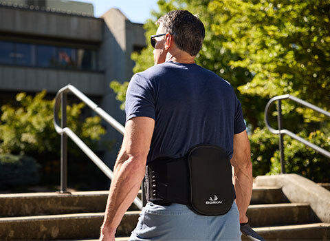 A man wearing a BioSkin back brace ascending stairs